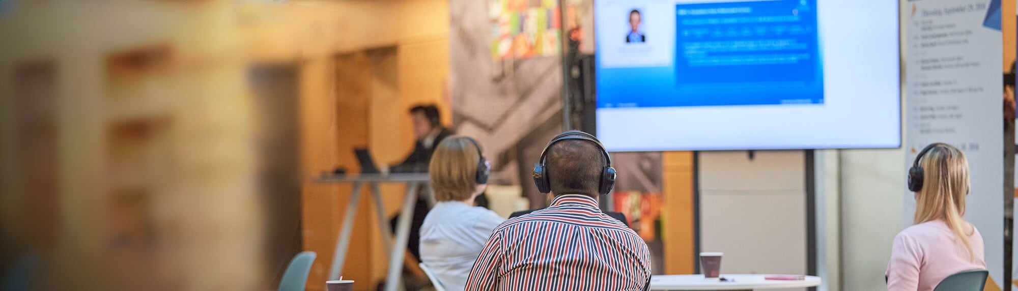 Employees watching screen banner