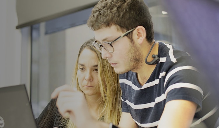Colleagues looking at laptop thumbnail
