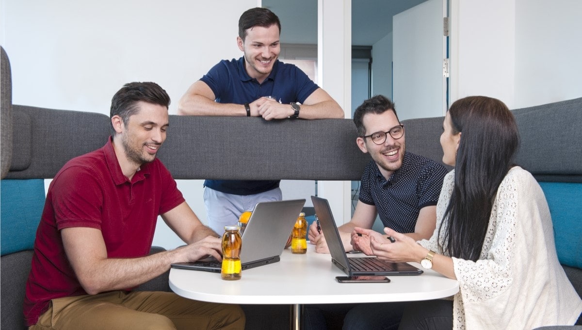four-pmi-employees-sitting-meeting-booth four-pmi-employees-sitting-meeting-booth