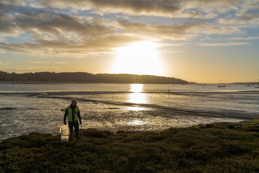 man-collecting-litter-on-a-beach man-collecting-litter-on-a-beach