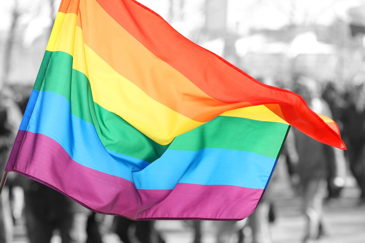 Rainbow flag waving in the wind, symbolising the LGBTQ+ community.