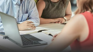 Employees sitting round a laptop