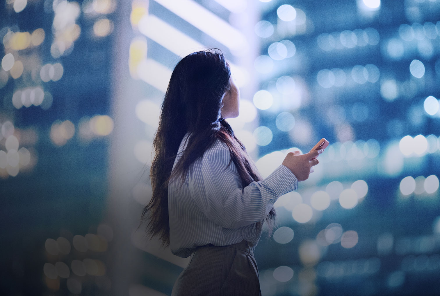 Woman holding phone in a city