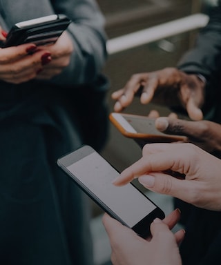 People's hands touching mobile phones