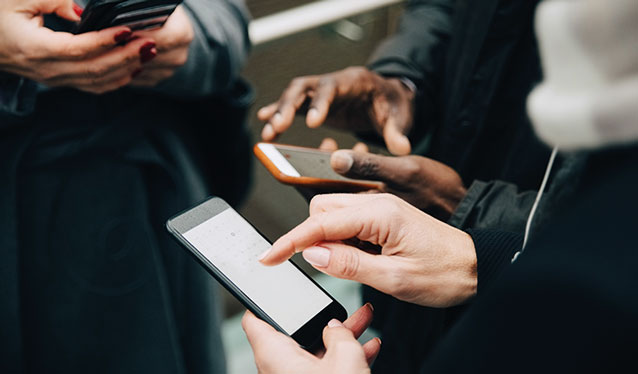 People's hands touching mobile phones