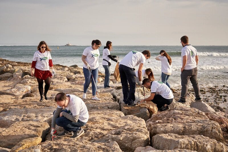 PMI employees cleaning up a beach in Portugal.