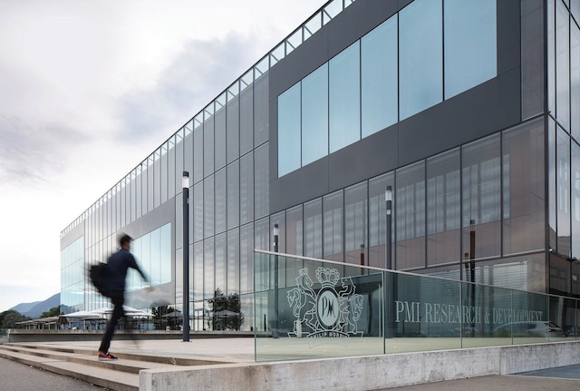 A man walking up steps to the entrance of PMI’s research and development facility in Neuchâtel, Switzerland.