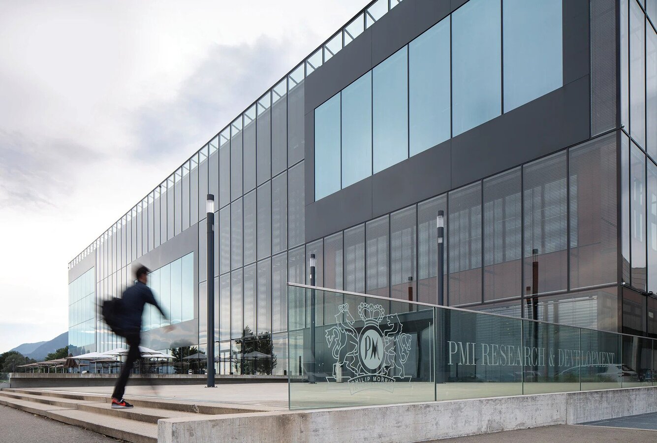 A man walking up steps to the entrance of PMI’s research and development facility in Neuchâtel, Switzerland.