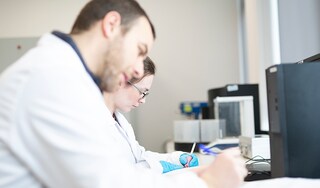 Two scientists writing in a lab