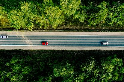 aerial-view-of-cars-driving-through-the-forest-on-XKMJATL