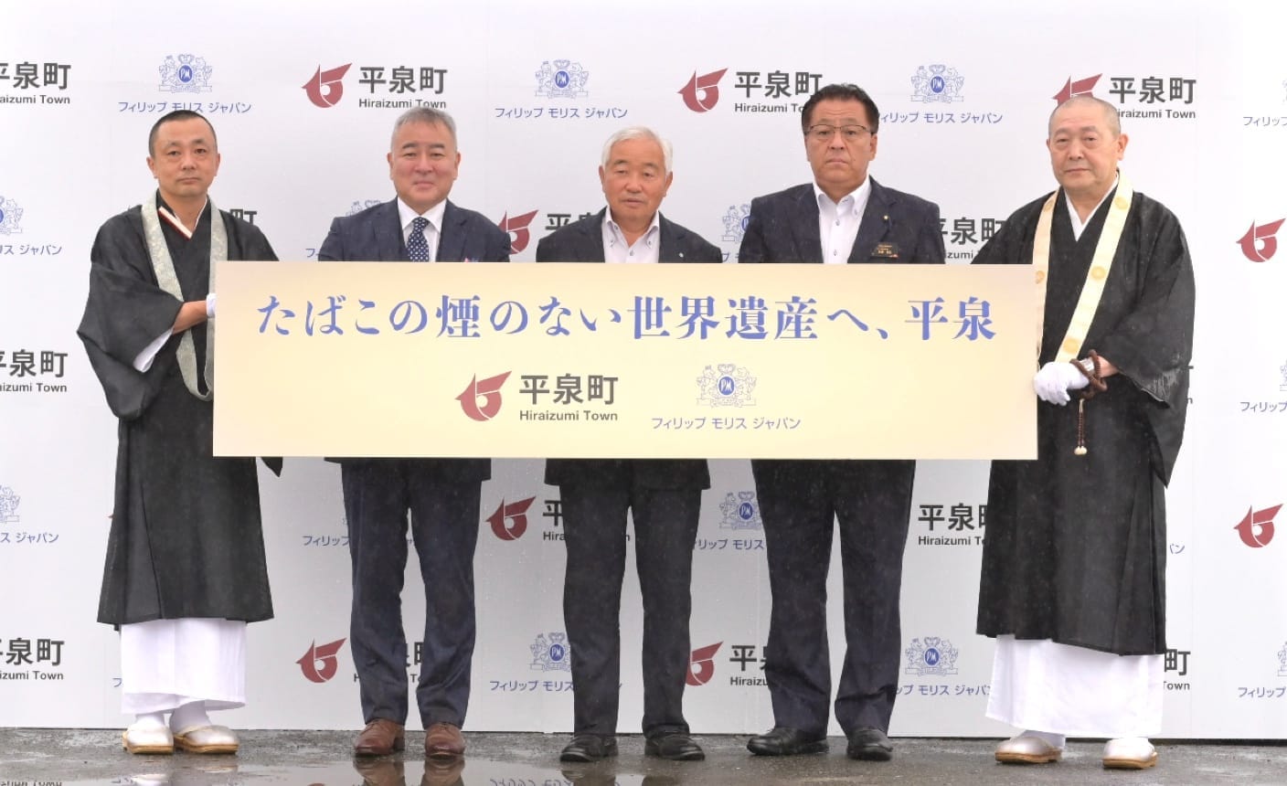 Five men holding up a sign showing that Hiraizumi, Japan, is a smoke-free town.