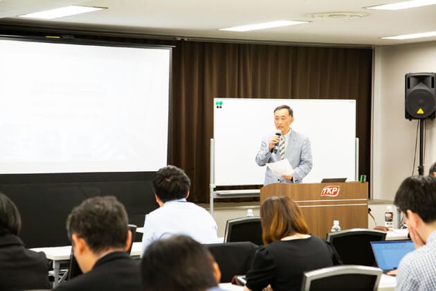 Man talking on a seminar in front of a group of people