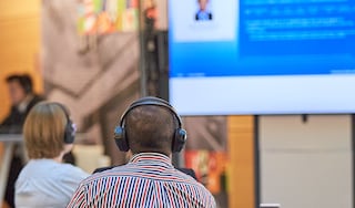 People wearing headphones and watching a monitor