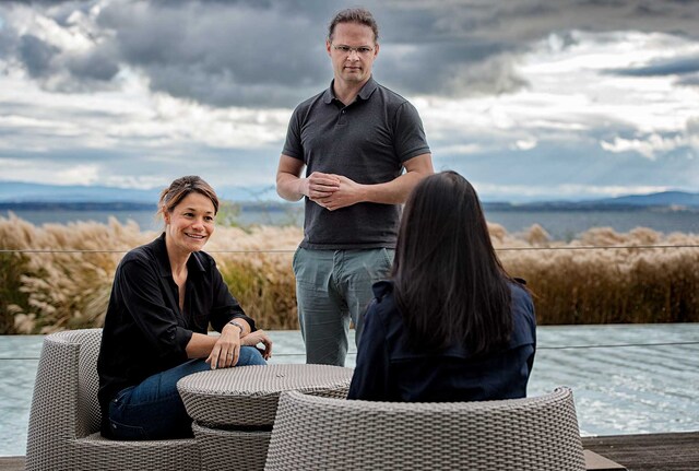 People sitting outside by a lake
