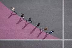 people walking diagonally along a line between grey and lilac colors