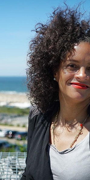 Smiling woman standing near a seaside resort