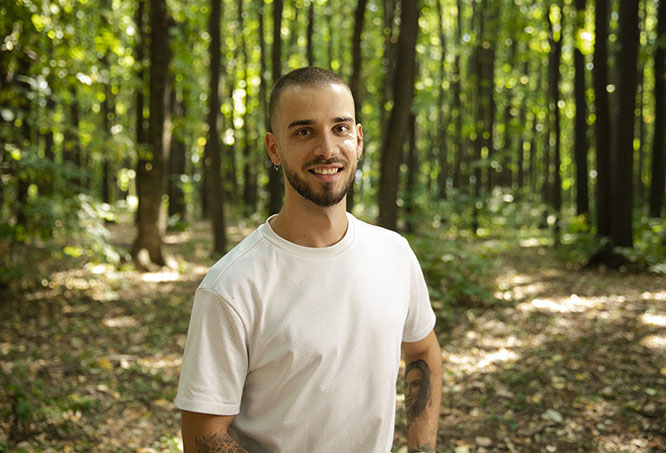 Tattooed man standing in a forest