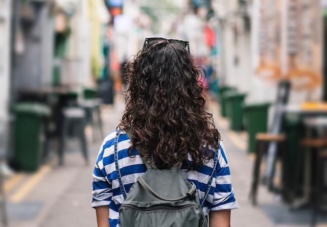 Young woman standing in a narrow city street