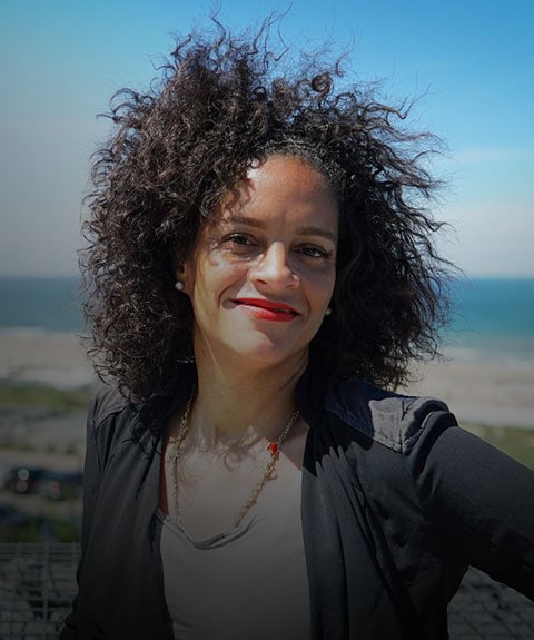 Smiling woman standing near a seaside resort