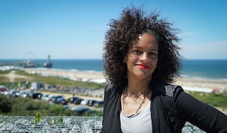 Woman standing by a coastal car park and beach