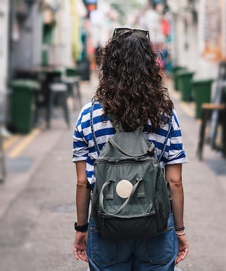 Young woman standing in a narrow city street