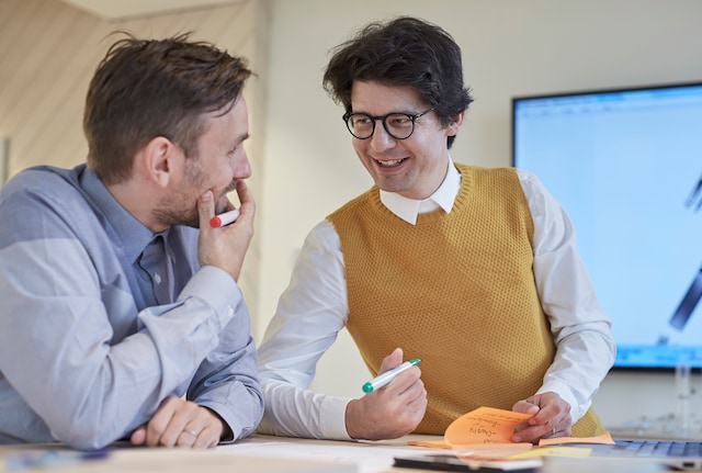 Two PMI employees discussing and smiling