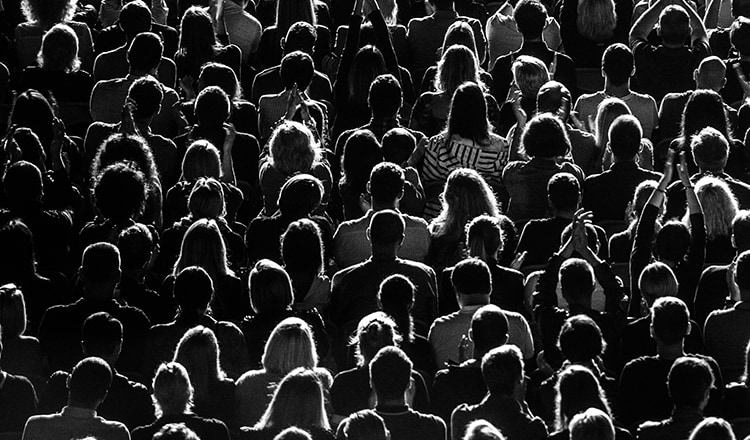 An ariel view of a crowd of people, showing the backs of their heads.
