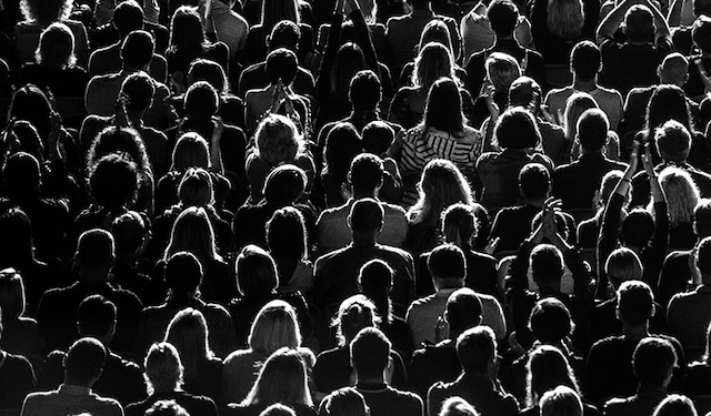 An ariel view of a crowd of people, showing the backs of their heads.