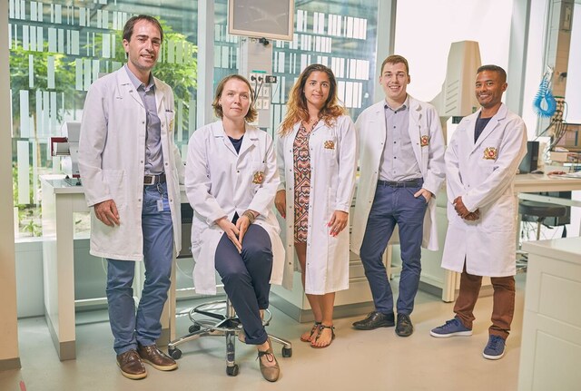 Group od scientists posing for a photo in PMI center cube, neuchatel.