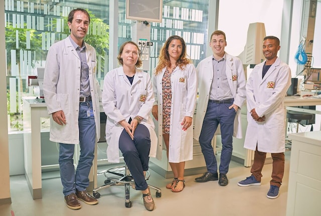 Group of scientists posing for a photo in PMI center cube, neuchatel.