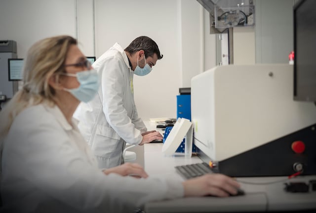 Scientists wearing masks in a laboratory