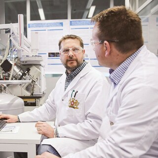 Scientists talking seated in a lab