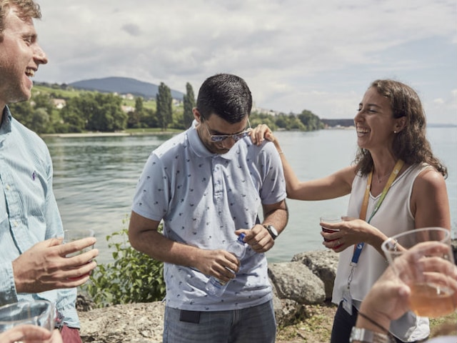 Laughing friends drinking by a lake