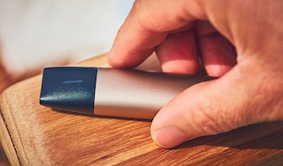 Man's hand holding a Veev e-vapor product