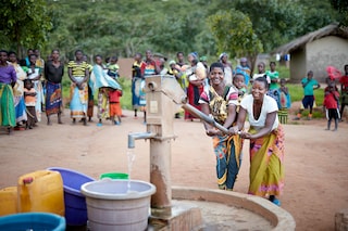Women pumping water from a community well in Mozambique.