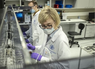 Two scientists wearing face masks in a laboratory