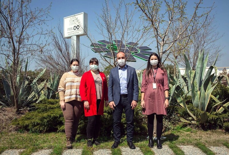 Four people standing in front of the PMI SA sign.