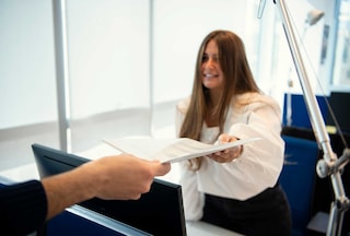 Woman handing a piece of paper to a male colleague