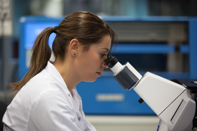 Scientist looking through microscope