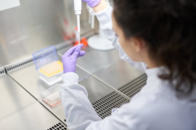 Scientist putting liquid in tube