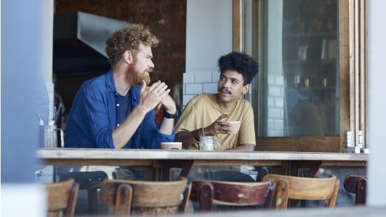 Two men drinking coffee in a café.