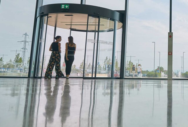 Two women approaching a revolving door