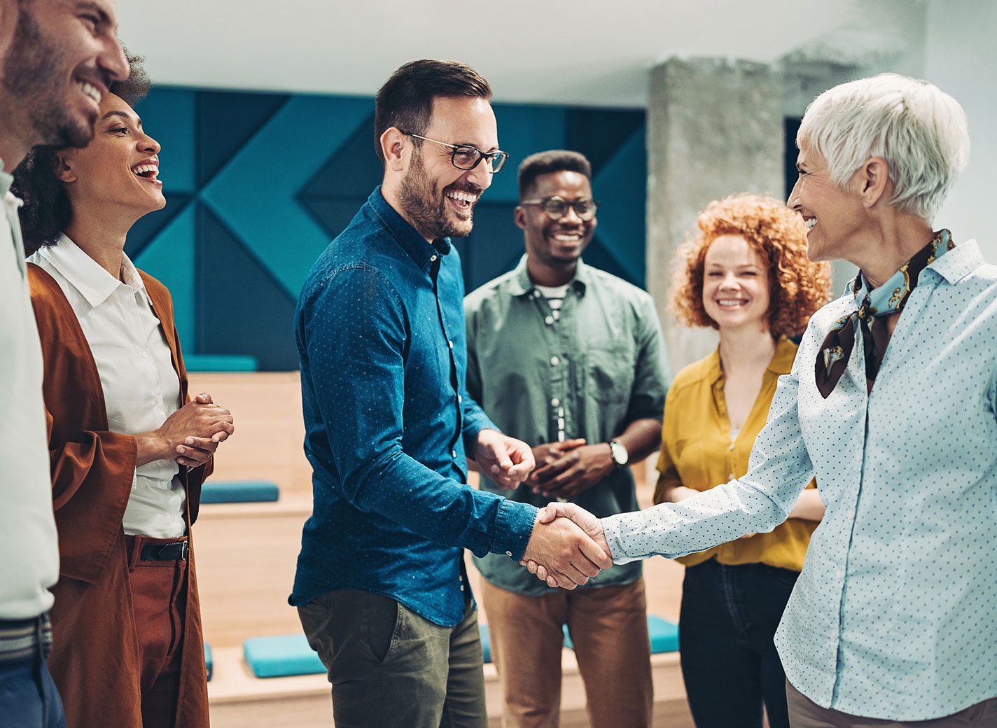 People shaking hands in informal office setting