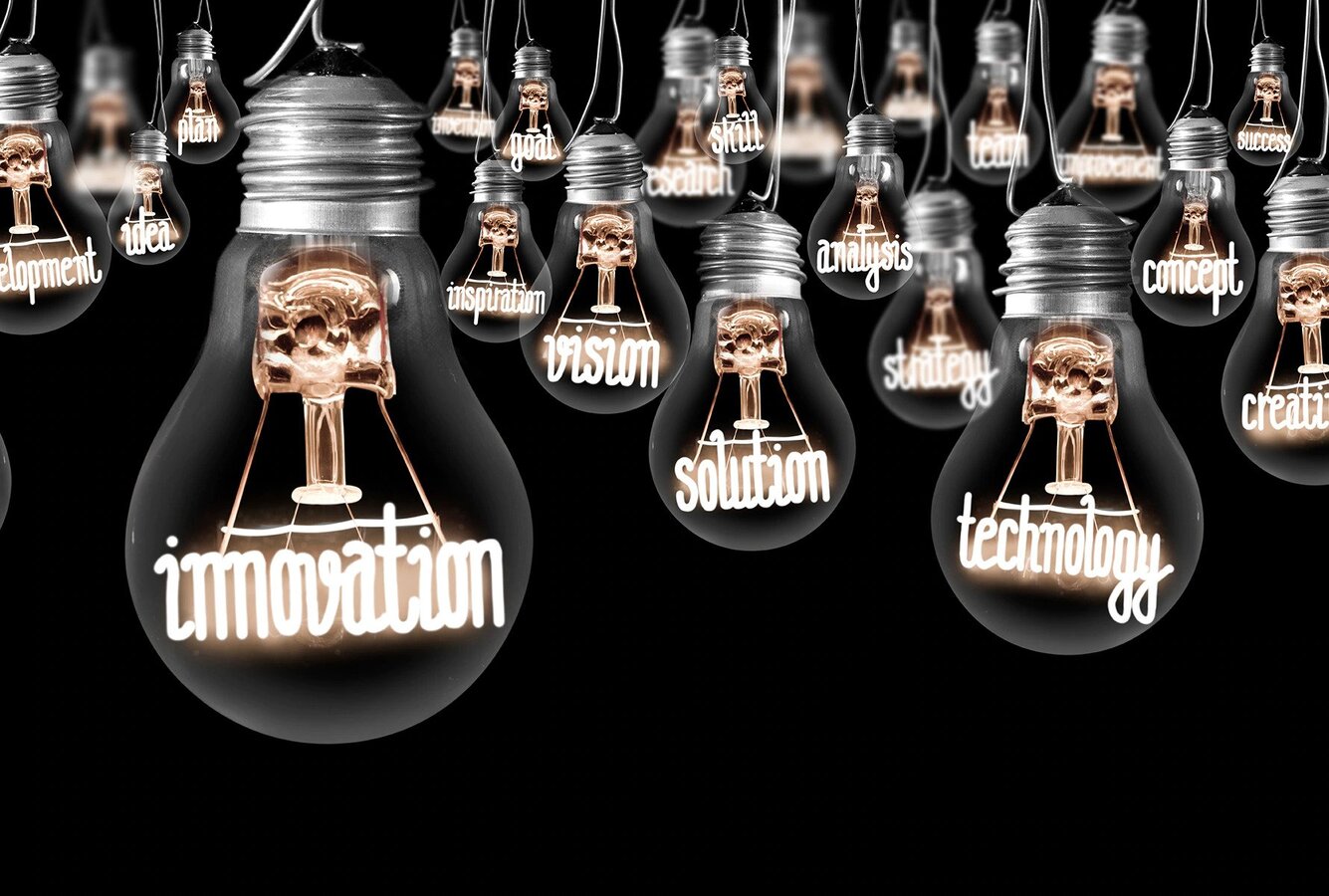 Lightbulbs with illuminated words inside them: technology, innovation, vision, etc.
