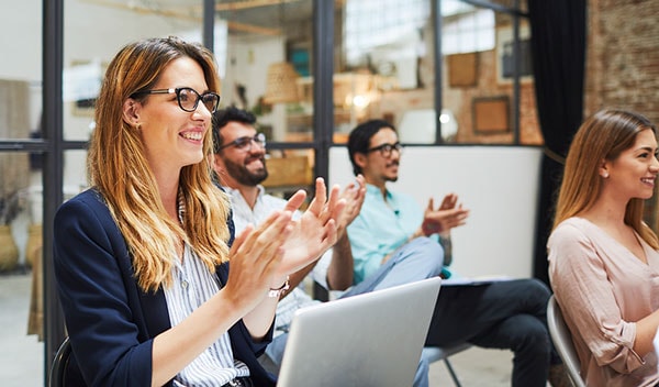 Men and women clapping in office