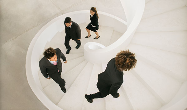 Business people climbing a spiral staircase