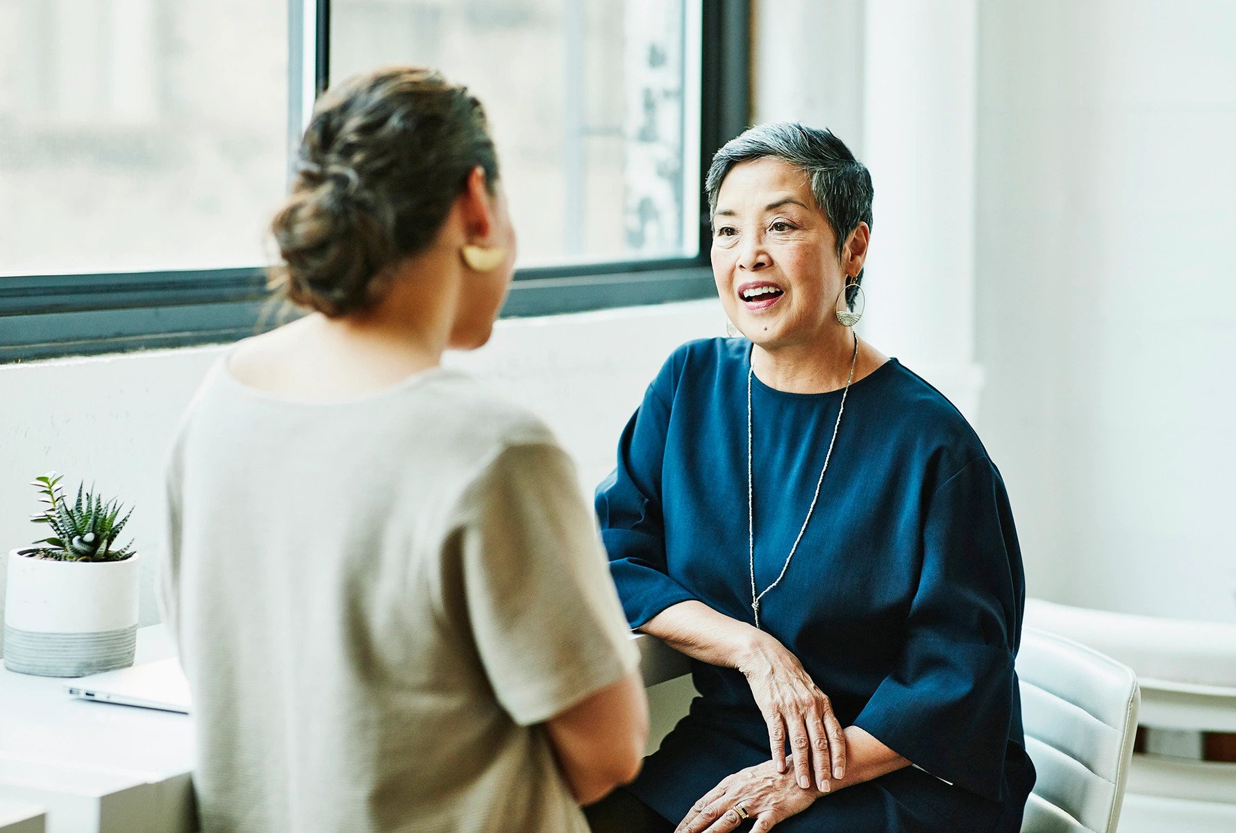 Two women sitting down and talking to each other