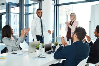 An employee receiving recognition from his team at work