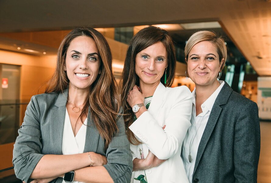 Three women posing in an office environment