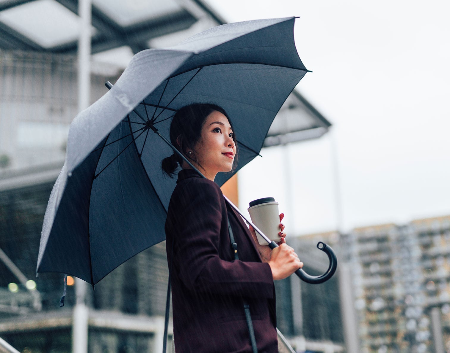 Woman looking optimistic under umbrella